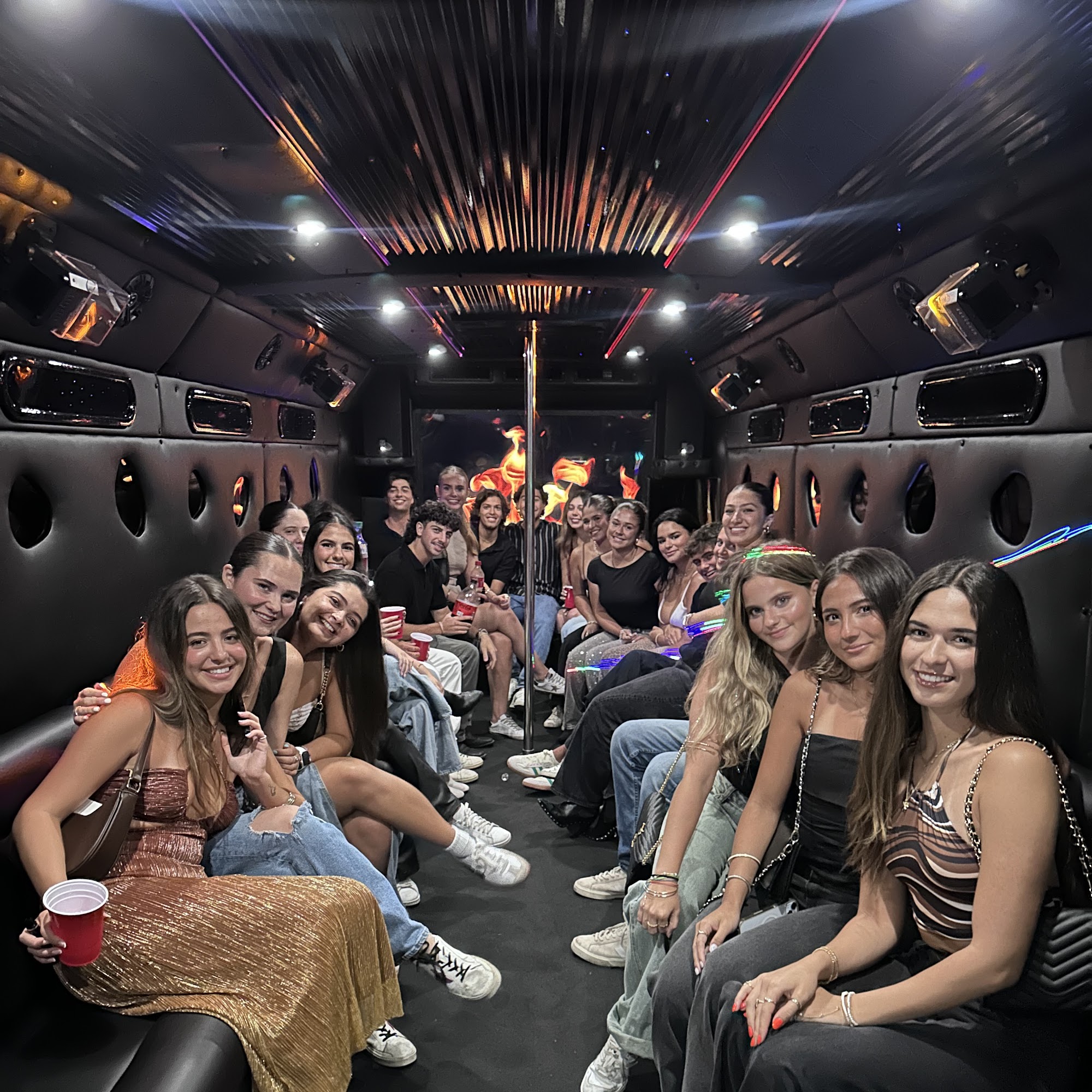 Young adults inside neon-lit party bus